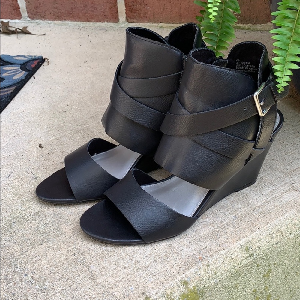 Black leather sandals with wedge heel.